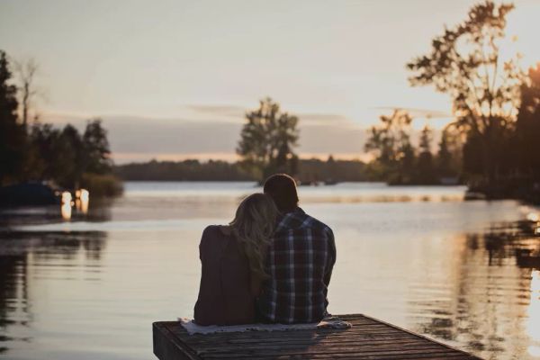A couple sitting by the water. | Source: Pexels