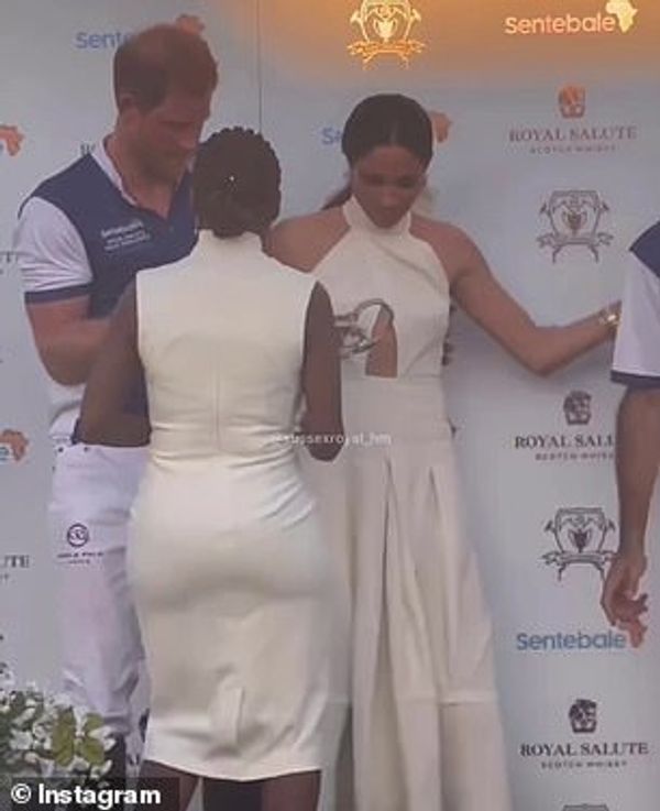 The move led to an awkward shuffle on stage as Meghan insisted on standing beside her husband